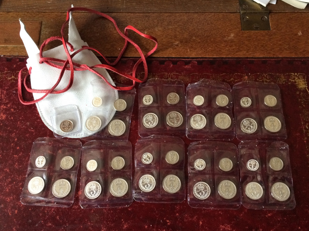 A white purse with Maundy coins laid out