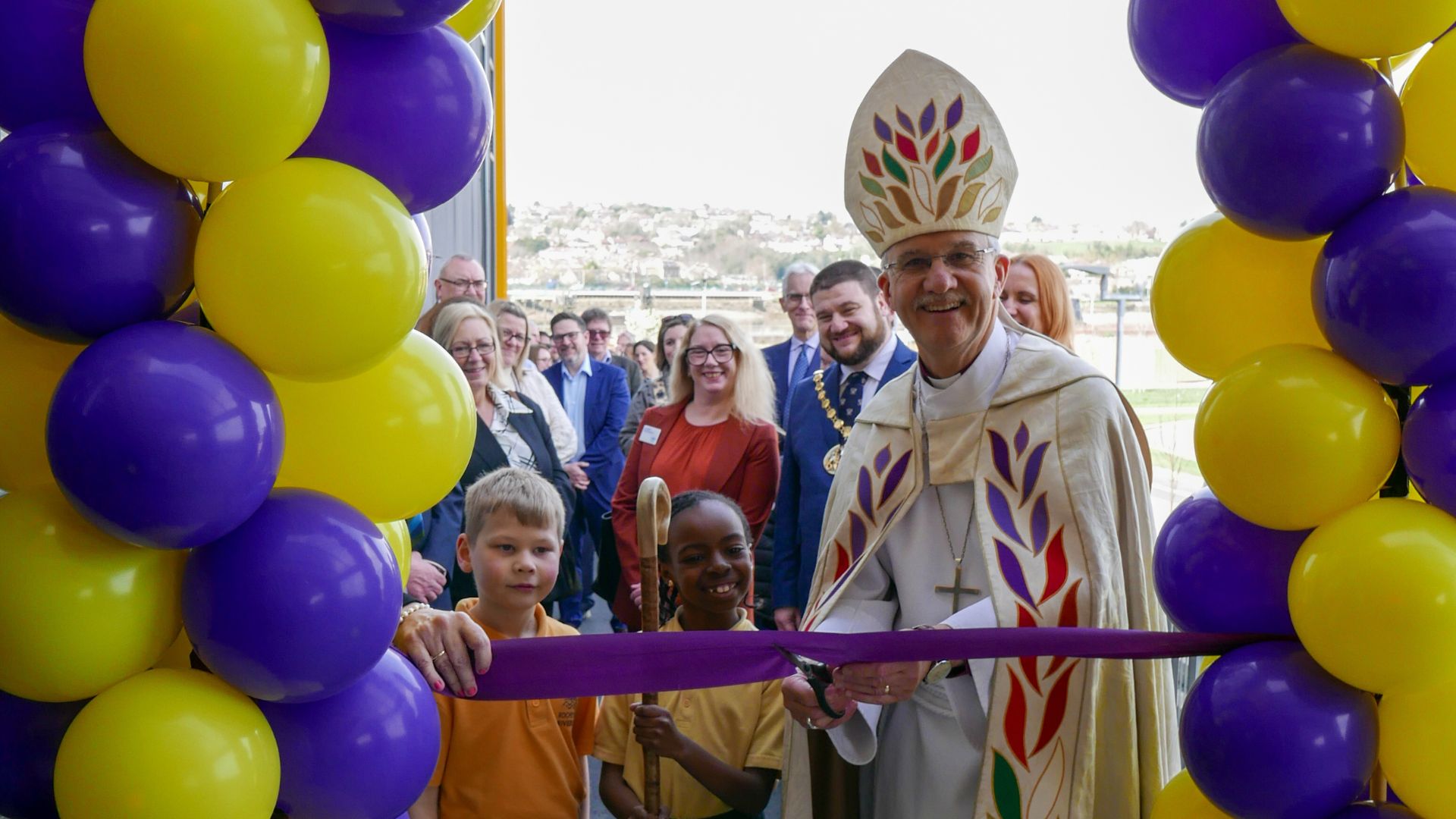 Bishop Jonathan is joined by two pupils as he cuts the ribbon