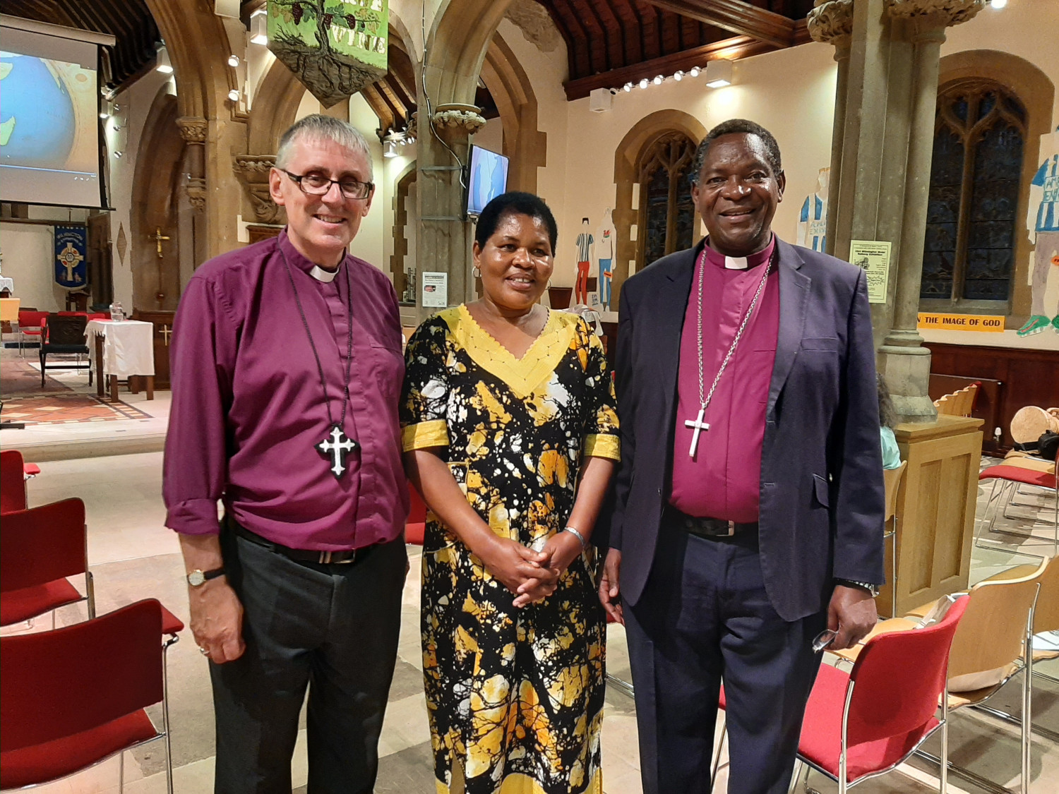 Bishop Simon, Rev Lilian and Bishop Given stand smiling at the camera inside the church