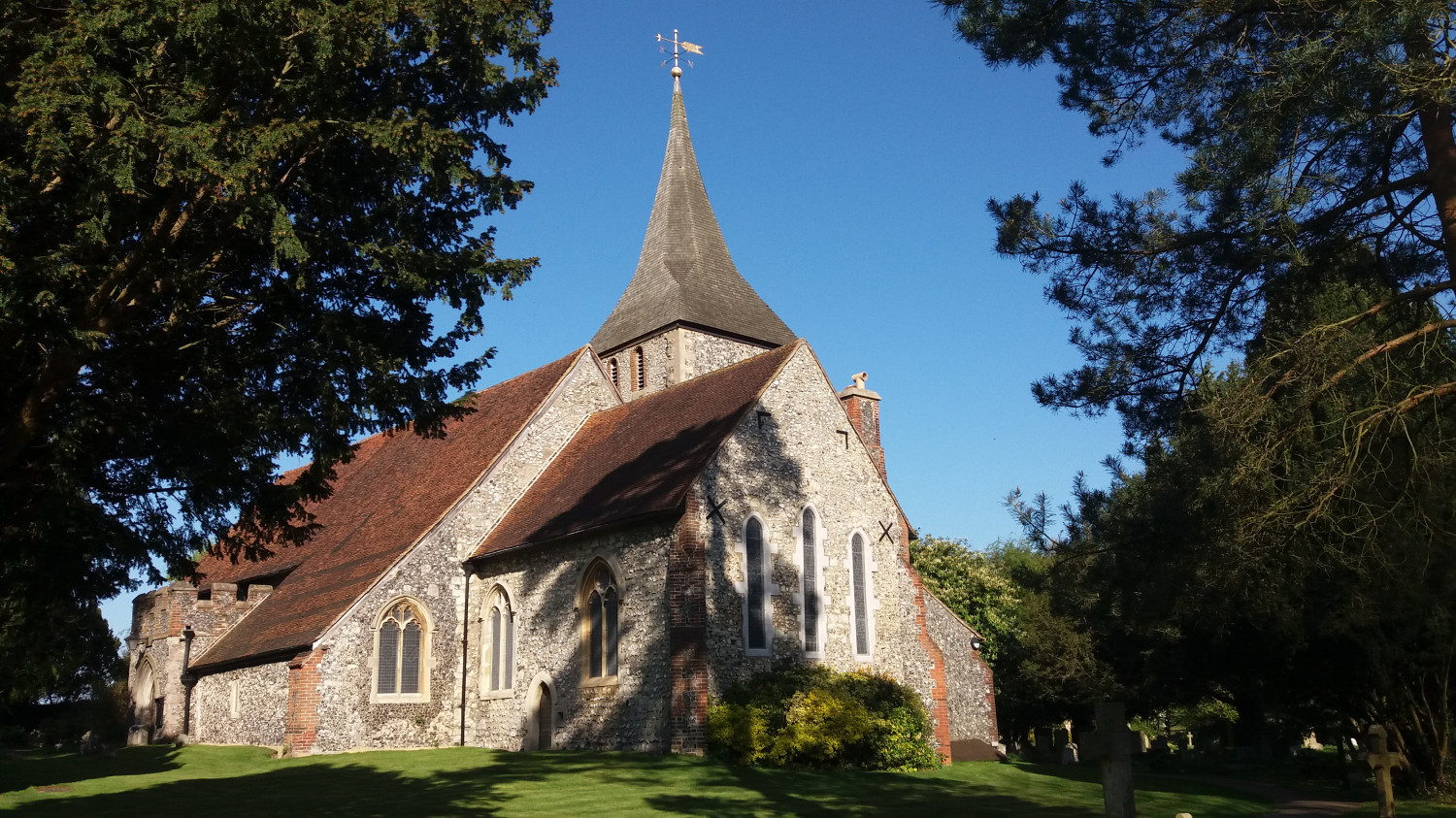 An outside view of St Martin of Tours church bathed in sunshine.