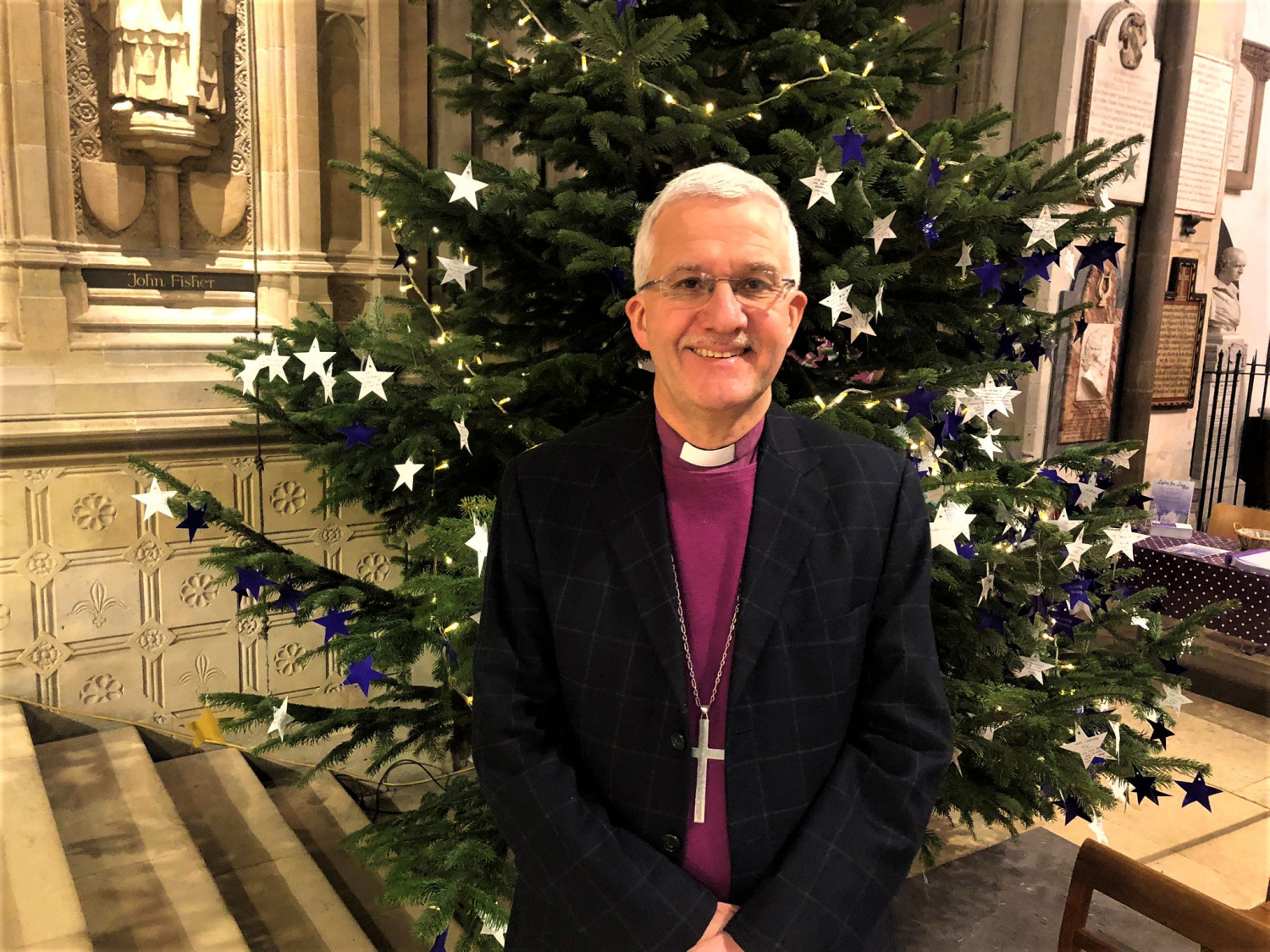 Bishop Jonathan stands in front of the Christmas tree in Rochester Cathedral